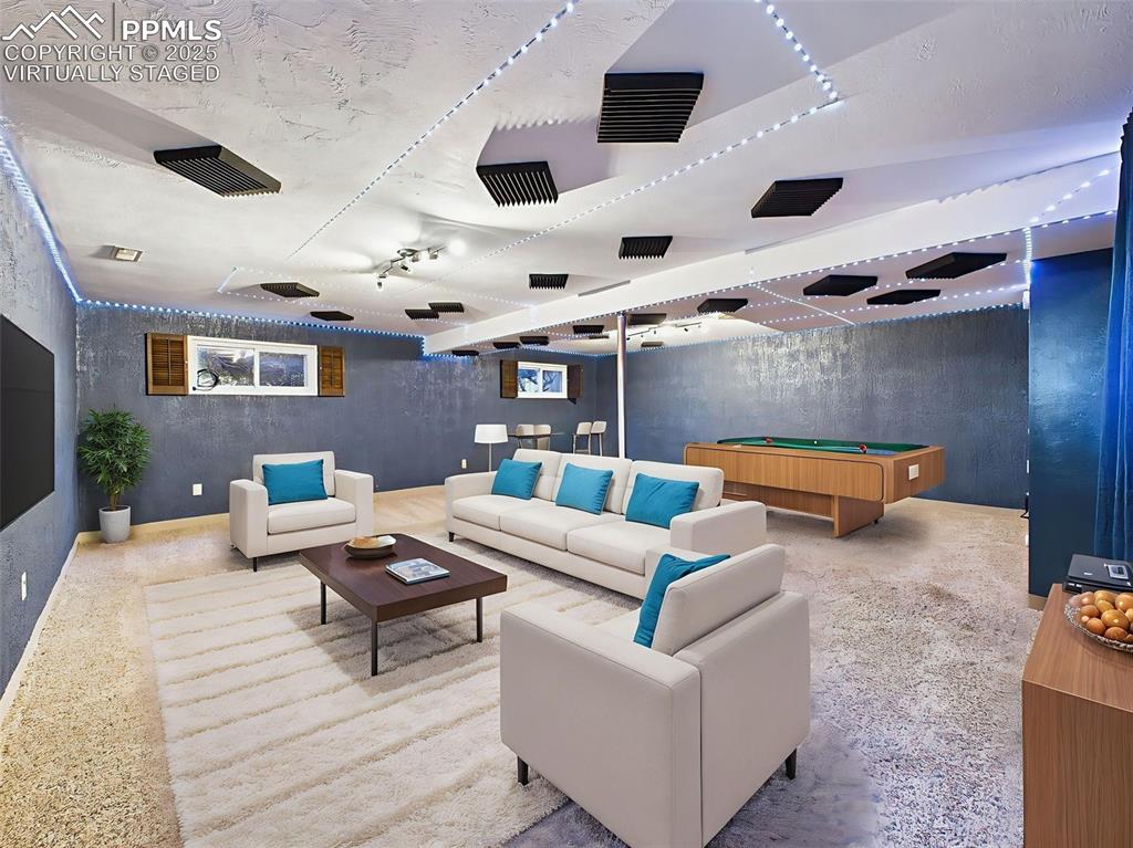 Virtually staged to show a fun and functional rec room, this finished basement offers room for games, lounging, and entertaining.