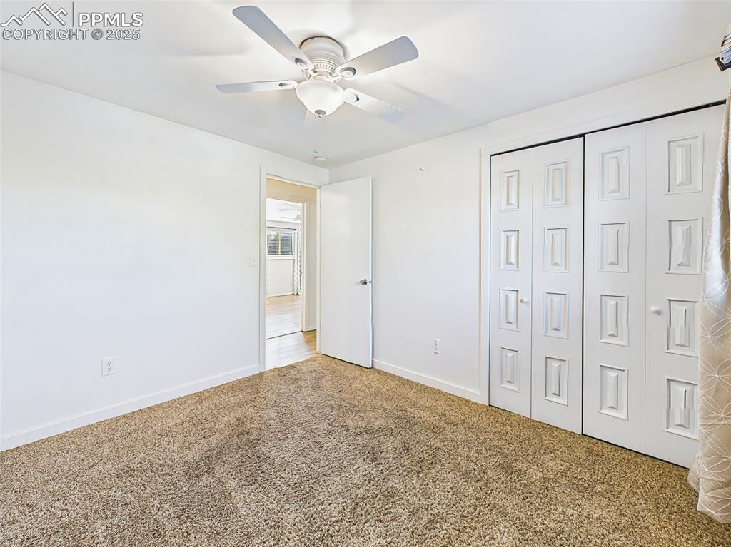 Large and versatile, this bedroom includes a ceiling fan, wide closet doors, and neutral finishes throughout.