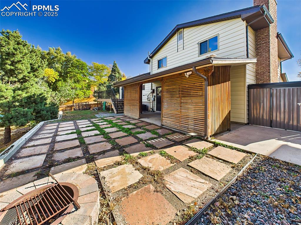 The fully fenced backyard includes a flagstone patio, raised garden beds, and a custom slatted privacy screen—perfect for outdoor entertaining.