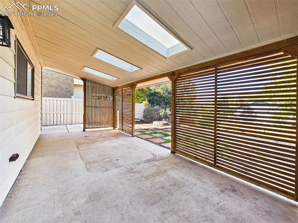 Unique covered patio with privacy slats and skylights—an ideal spot for shade and relaxation year-round.