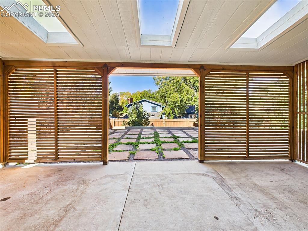 The patio opens directly to the backyard and stone-paved area, seamlessly connecting indoor and outdoor living.