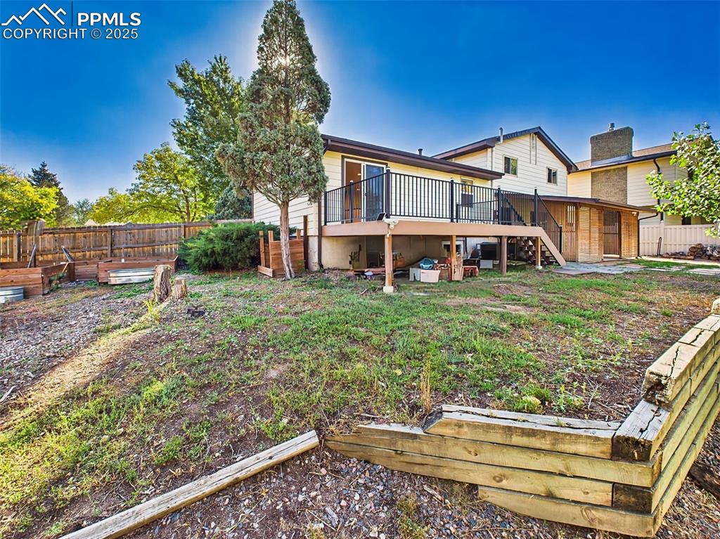 A clear view of the home's rear exterior, showcasing the raised composite deck, private covered patio, and ample yard space.