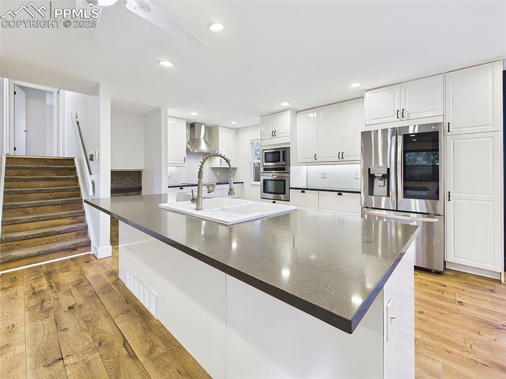 Expansive kitchen island with deep farmhouse sink, sleek black countertops, and bar seating—perfect for meal prep or casual gatherings.