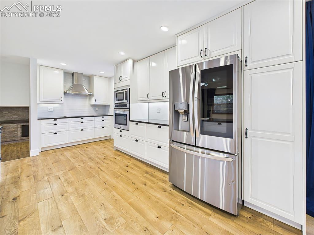 Stainless steel French door refrigerator is flanked by tall pantry cabinets, offering extensive storage and a polished, built-in look.