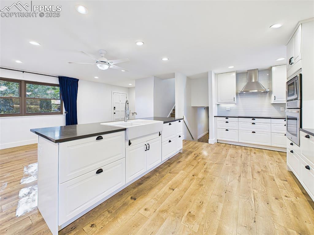 Wide-angle view highlights the kitchen island’s central role in this open-concept floor plan, framed by natural light and clean lines.