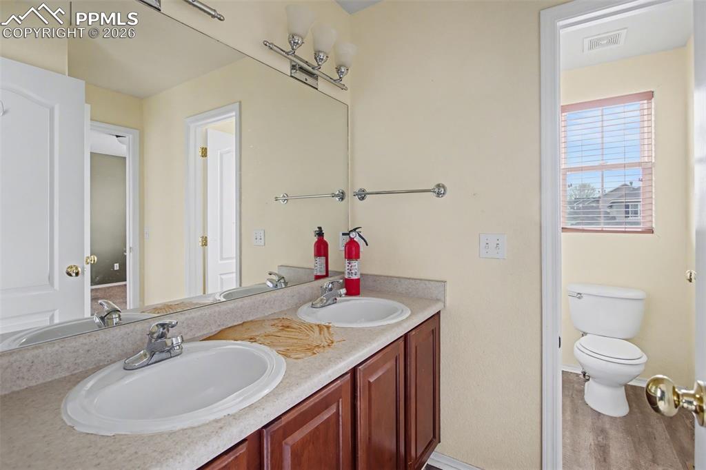 Full bathroom featuring double vanity and light wood-style flooring