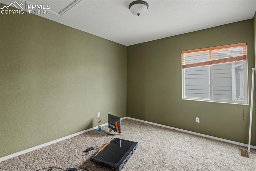 Workout area with baseboards and light carpet