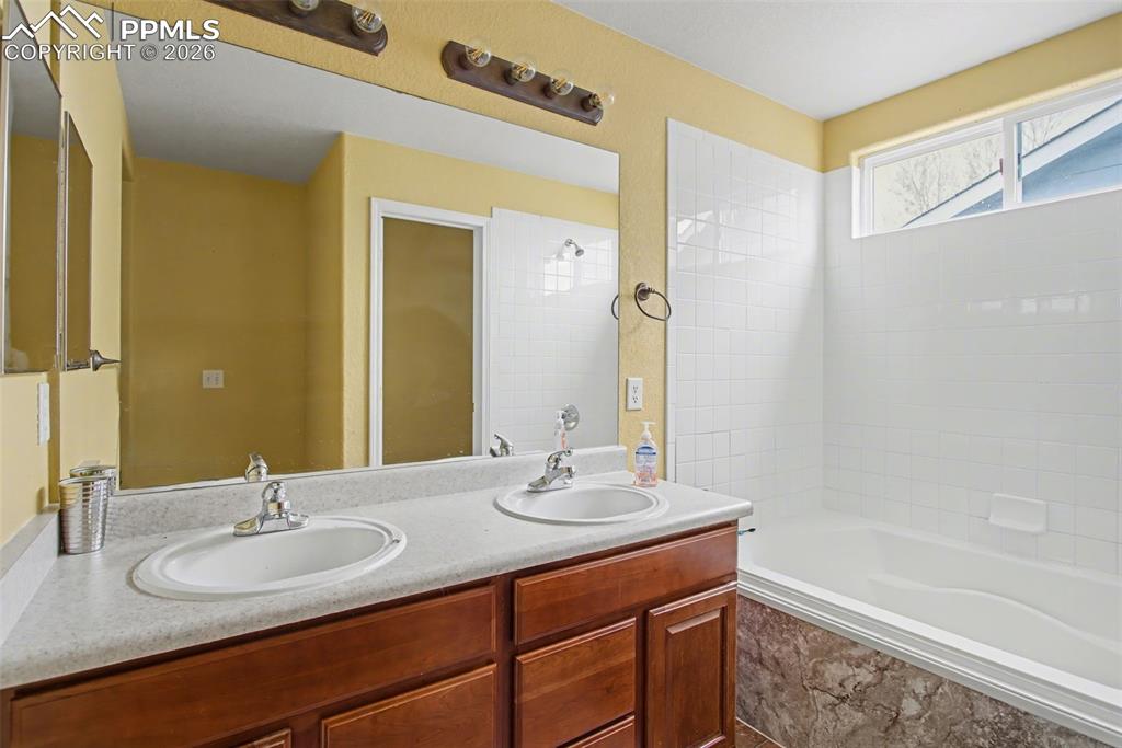 Bathroom featuring double vanity and shower / tub combination