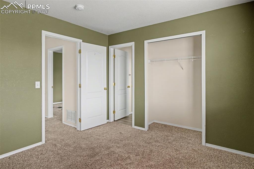Unfurnished bedroom featuring light carpet and a closet
