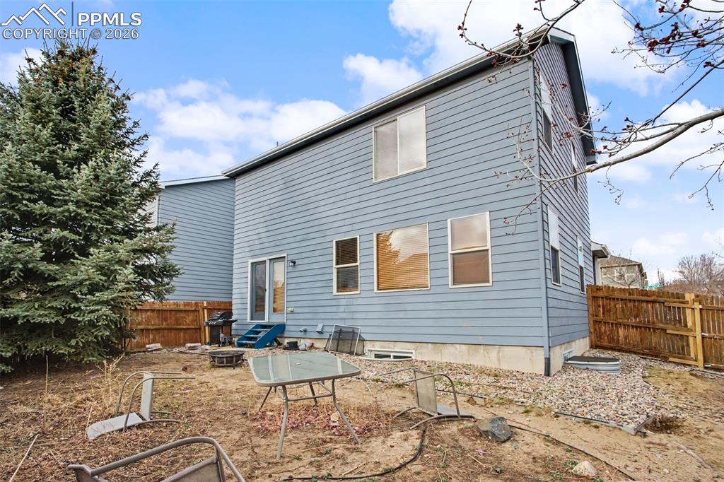 Rear view of property featuring a fenced backyard and a patio