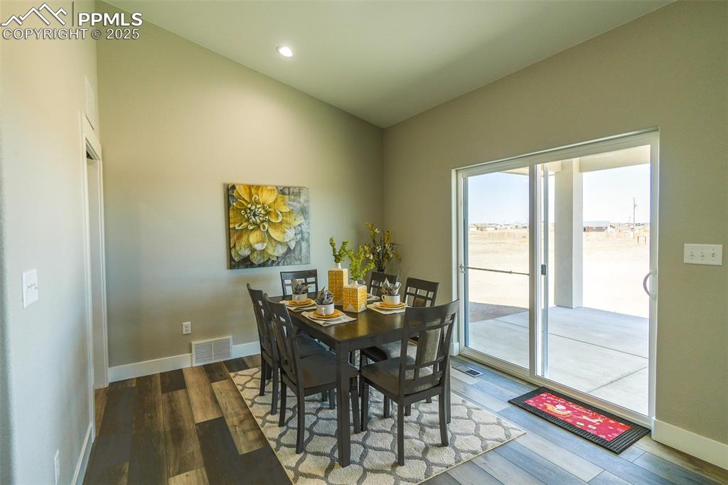 Dining room featuring lofted ceiling and LTV / wood-style floors