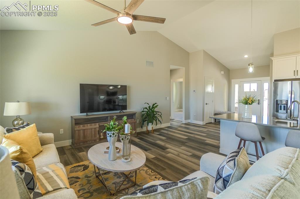 Living room featuring LTV / wood-style flooring, sink, high vaulted ceiling, and ceiling fan
