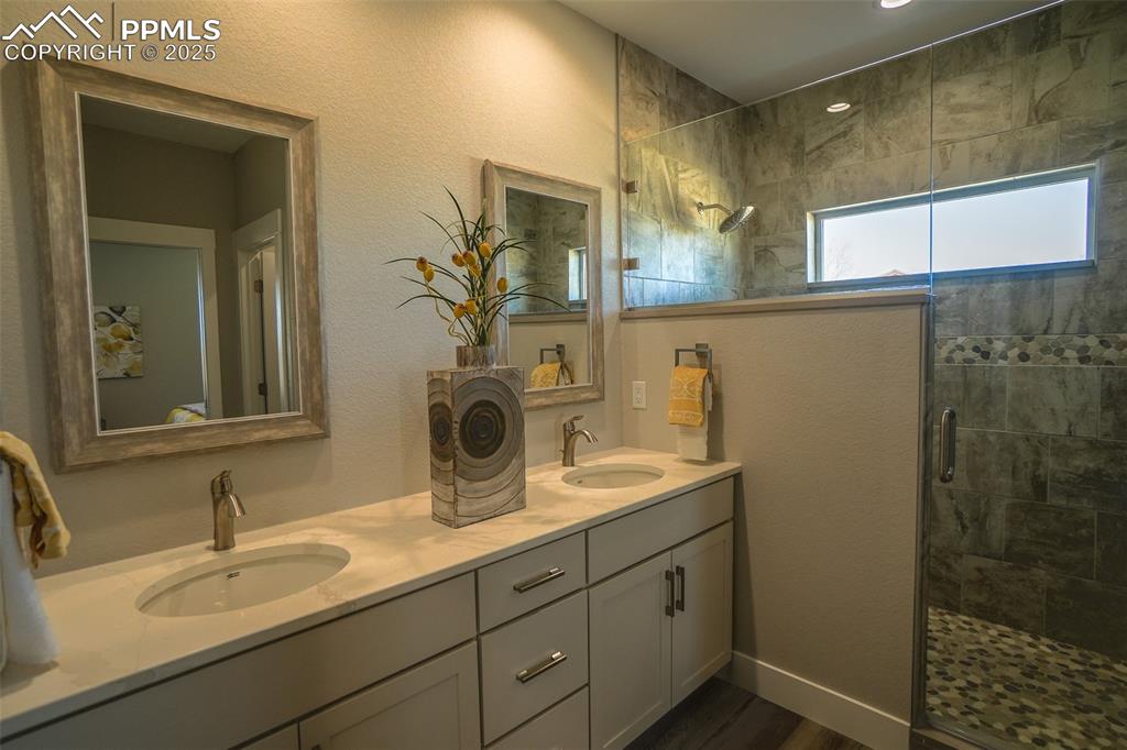 Bathroom featuring dual vanity and an enclosed shower
