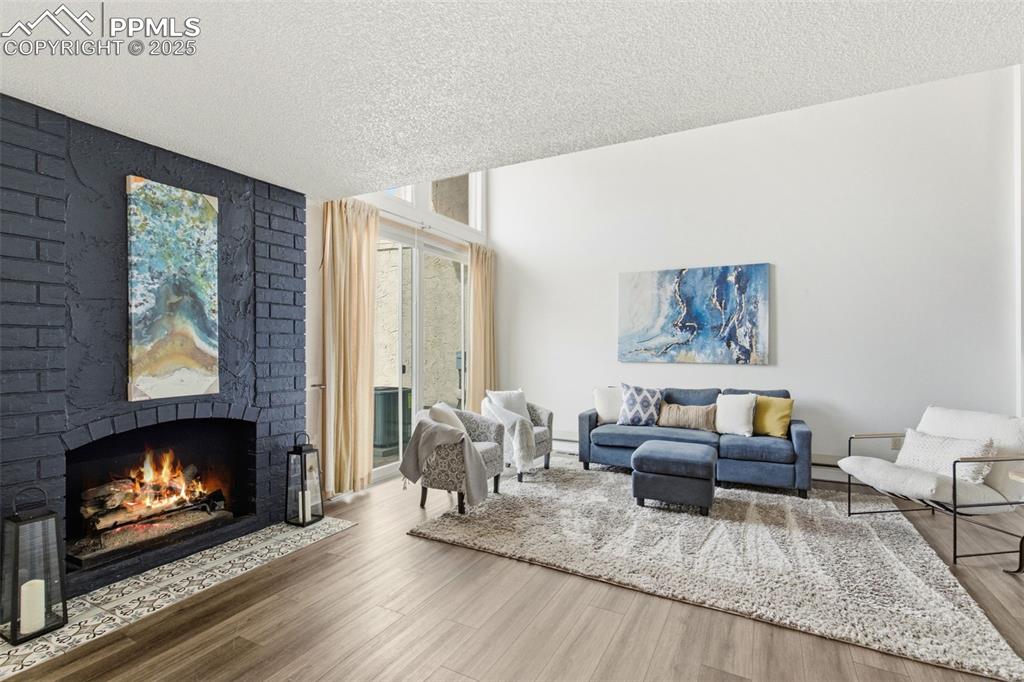Living room with a brick fireplace, and a wall of windows