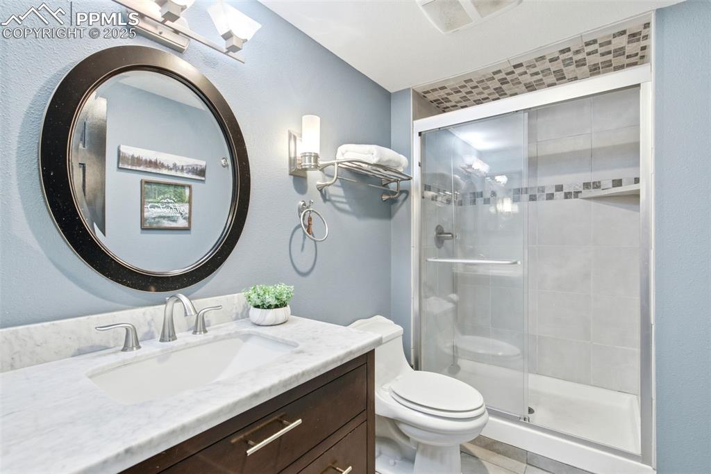Bathroom with vanity, a stall shower