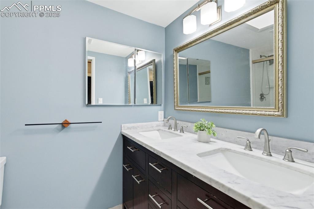 Bathroom featuring double vanity and a shower with door