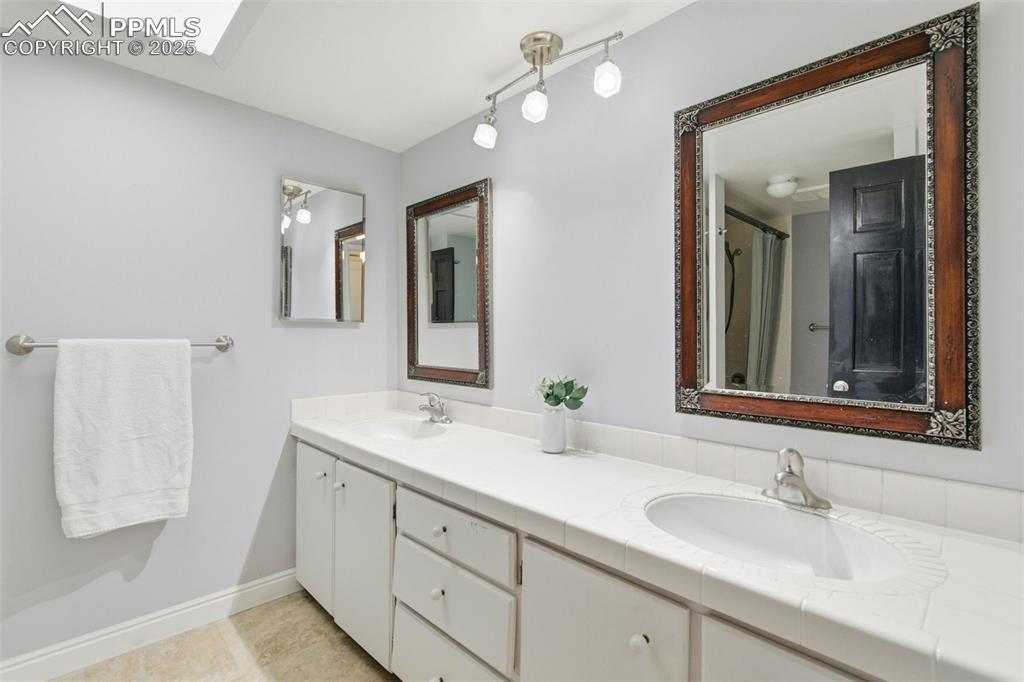 Bathroom featuring skylight and large vanity