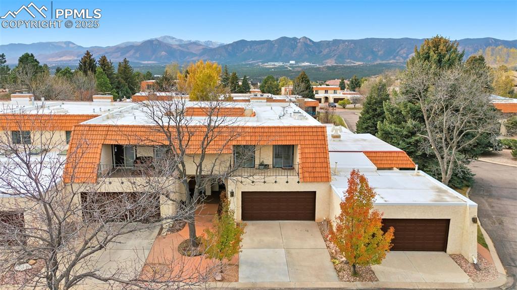 View of front of home featuring a mountain view, stucco siding, and concrete driveway