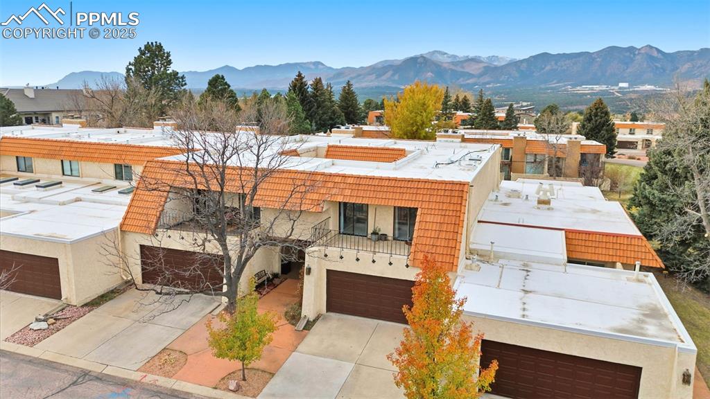 View of front of home featuring a mountain view, stucco siding, and driveway