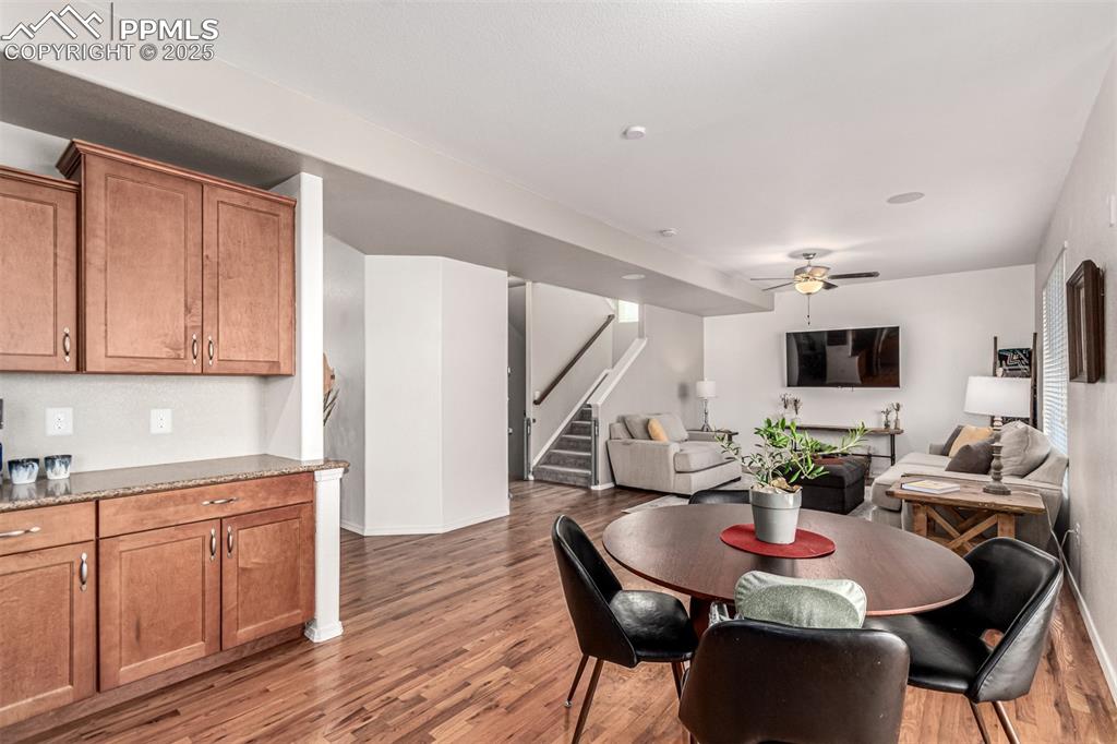 Dining space with stairway, light wood-style flooring, and ceiling fan