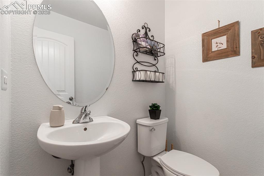 Half bathroom with a textured wall and toilet