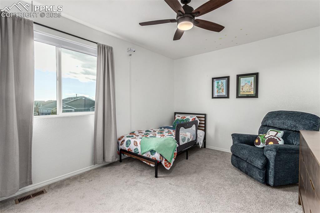 Bedroom featuring light colored carpet and ceiling fan