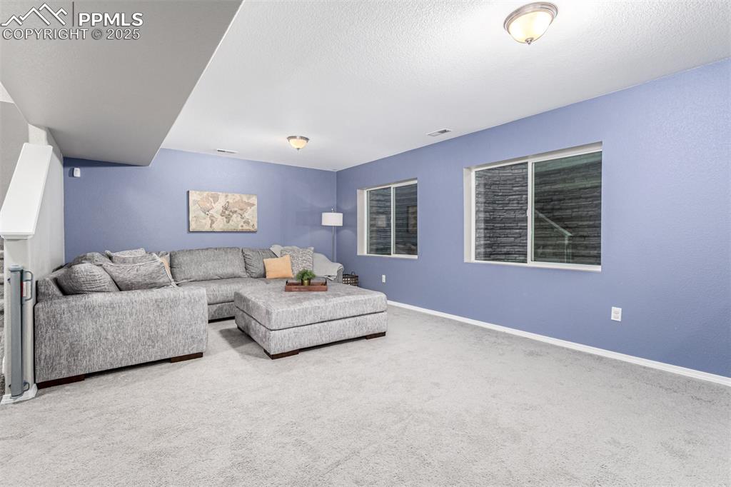 Carpeted living area featuring baseboards and a textured ceiling