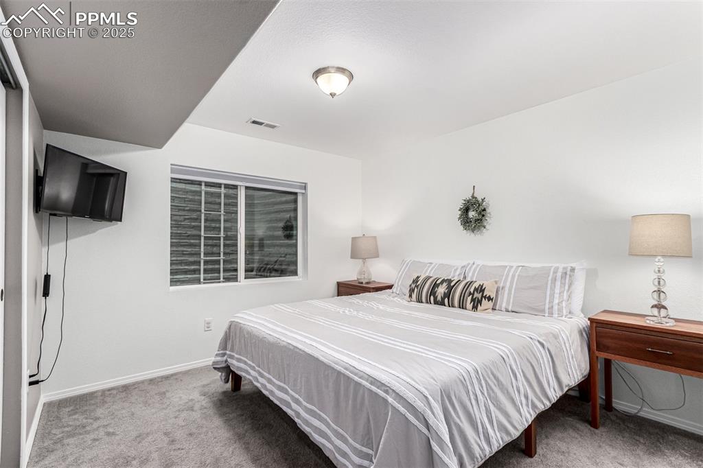 Bedroom featuring light carpet and baseboards
