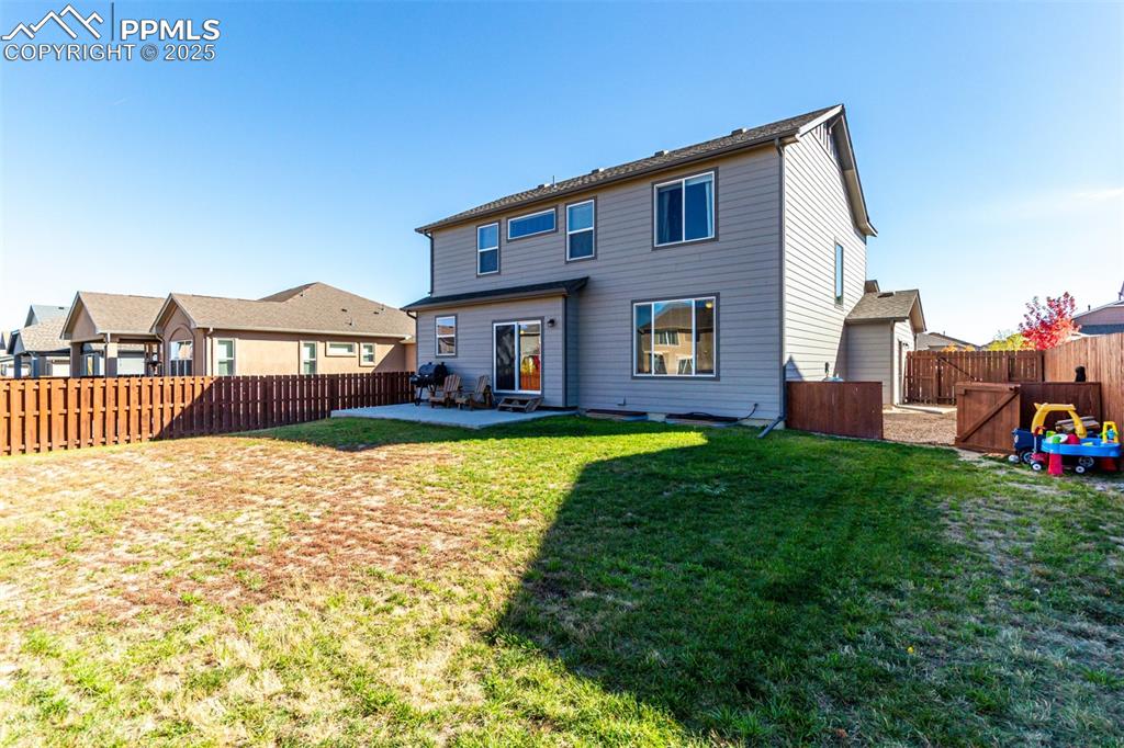 Rear view of house with a patio and a fenced backyard