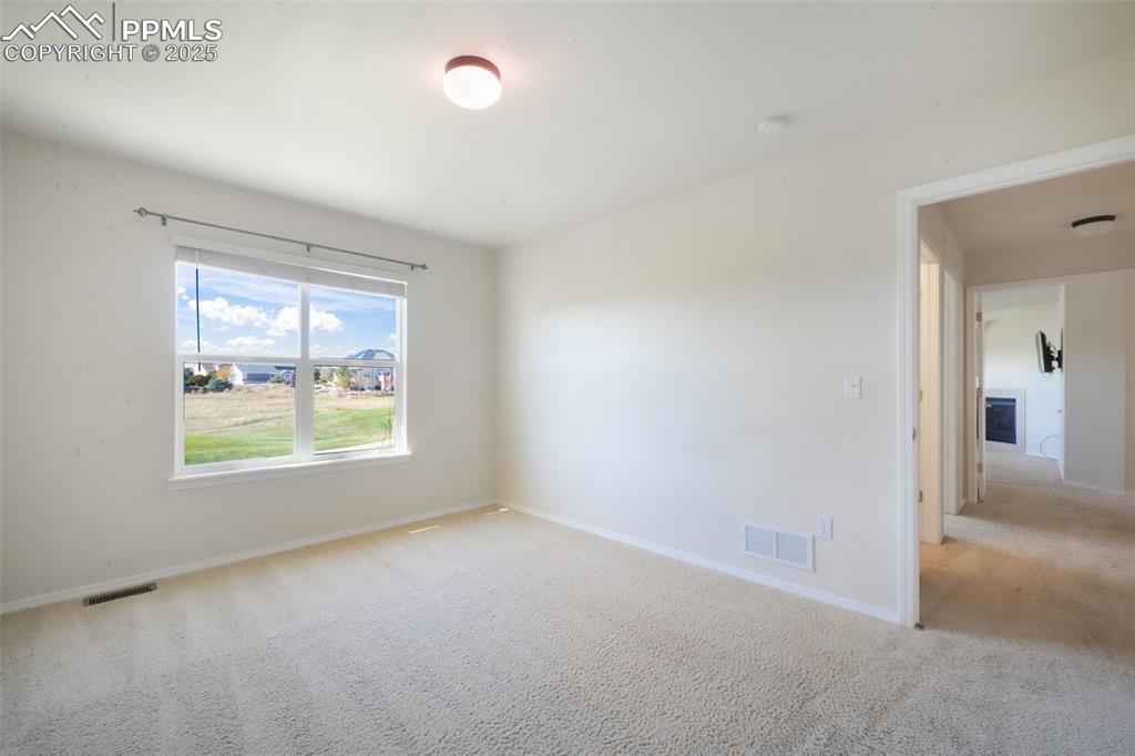 Empty room featuring light carpet and baseboards