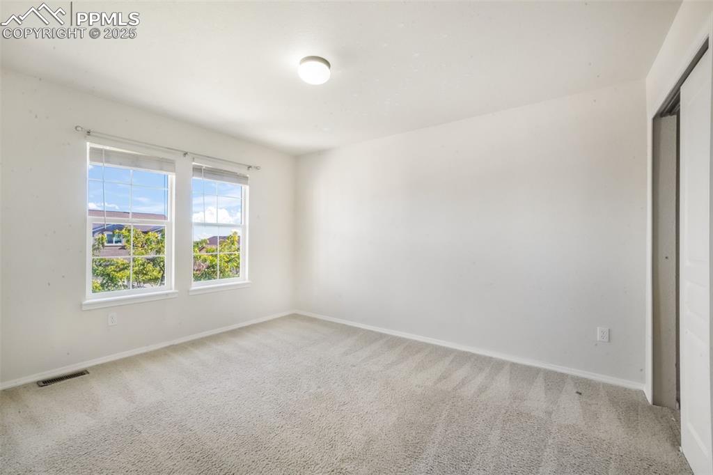 Spare room with light carpet and baseboards
