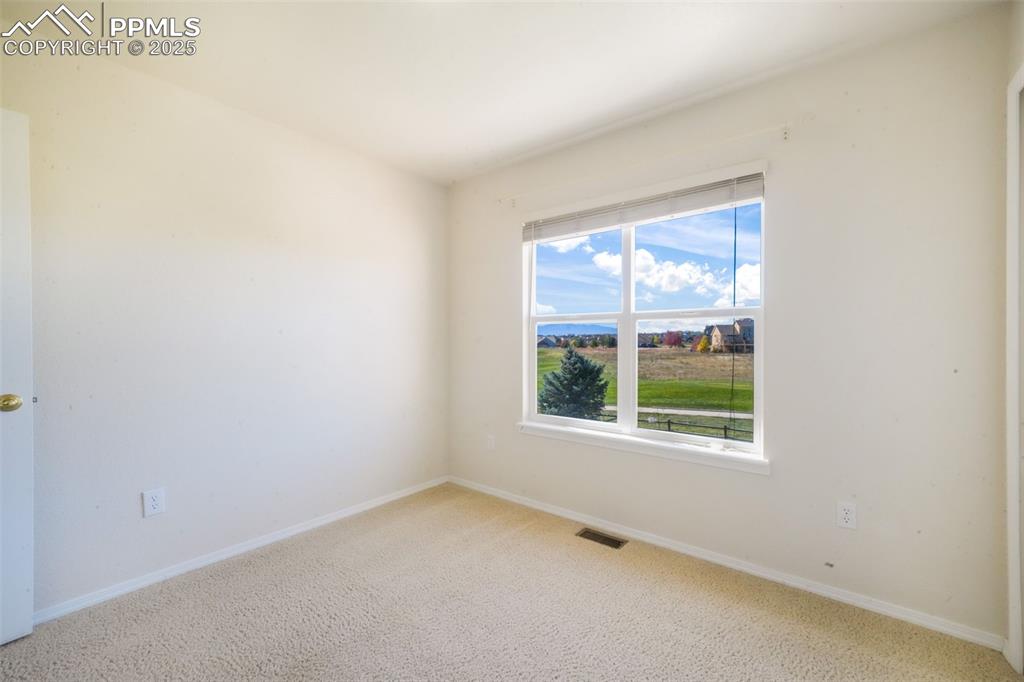Carpeted spare room with baseboards