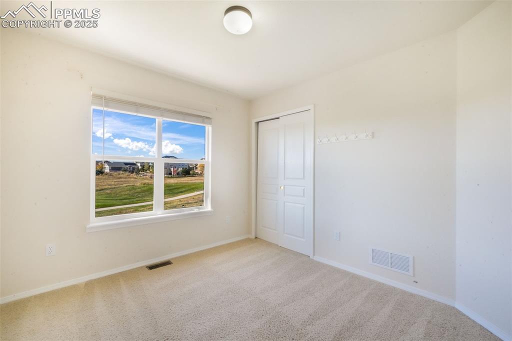 Unfurnished bedroom featuring carpet and a closet