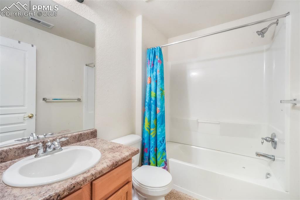Full bath featuring shower / bath combo with shower curtain and vanity