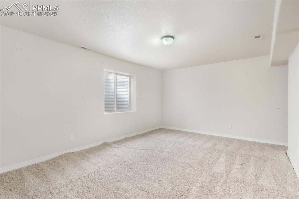 Spare room with light colored carpet and baseboards