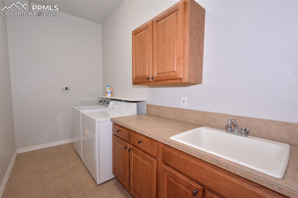 Laundry room on main level with utility sink/cabinets