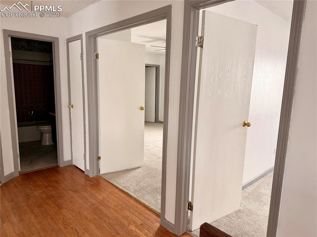 Hallway featuring light wood-type flooring and a textured ceiling