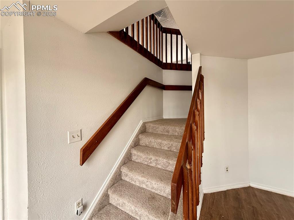 Stairs with baseboards and wood finished floors