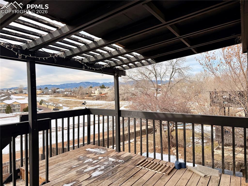 Wooden deck featuring a mountain view and a pergola