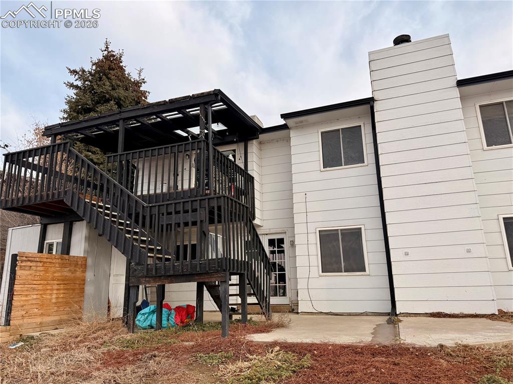 Back of house featuring stairs, a patio, and a wooden deck
