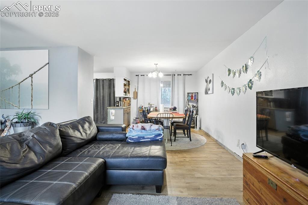 Living room featuring wood finished floors and a chandelier