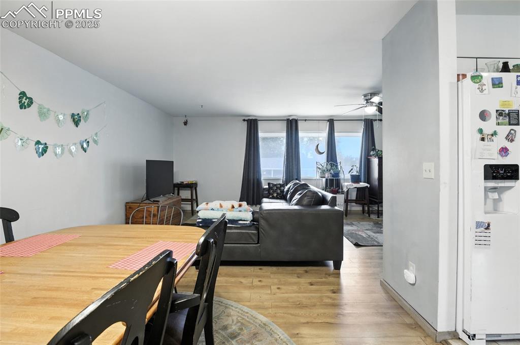 Dining space with light wood-style floors and a ceiling fan