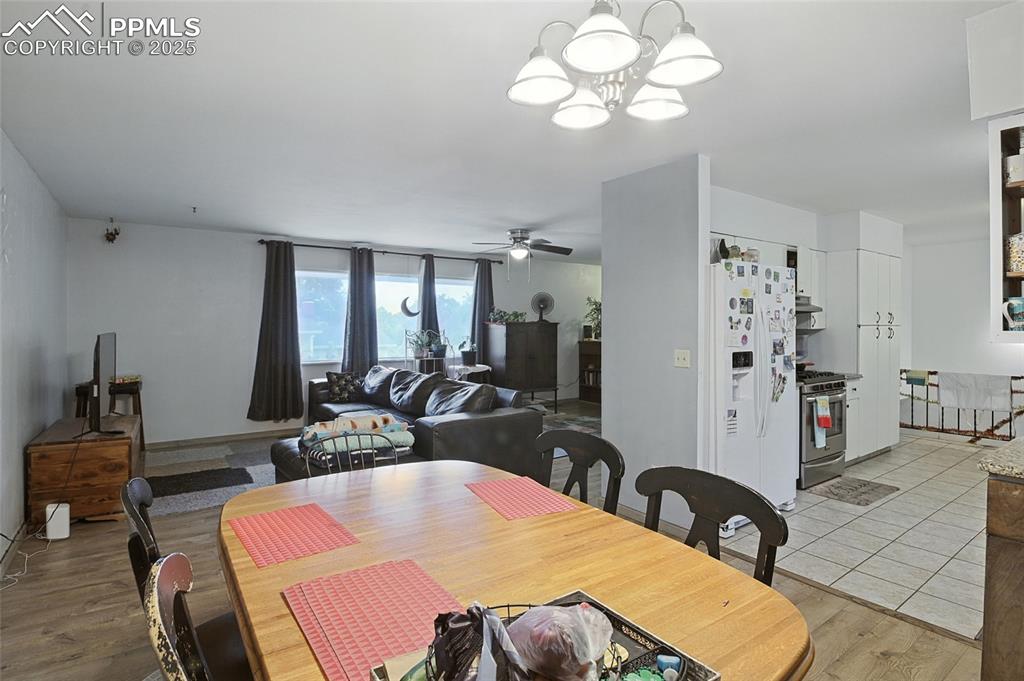 Dining space featuring a chandelier, light wood finished floors, and a ceiling fan
