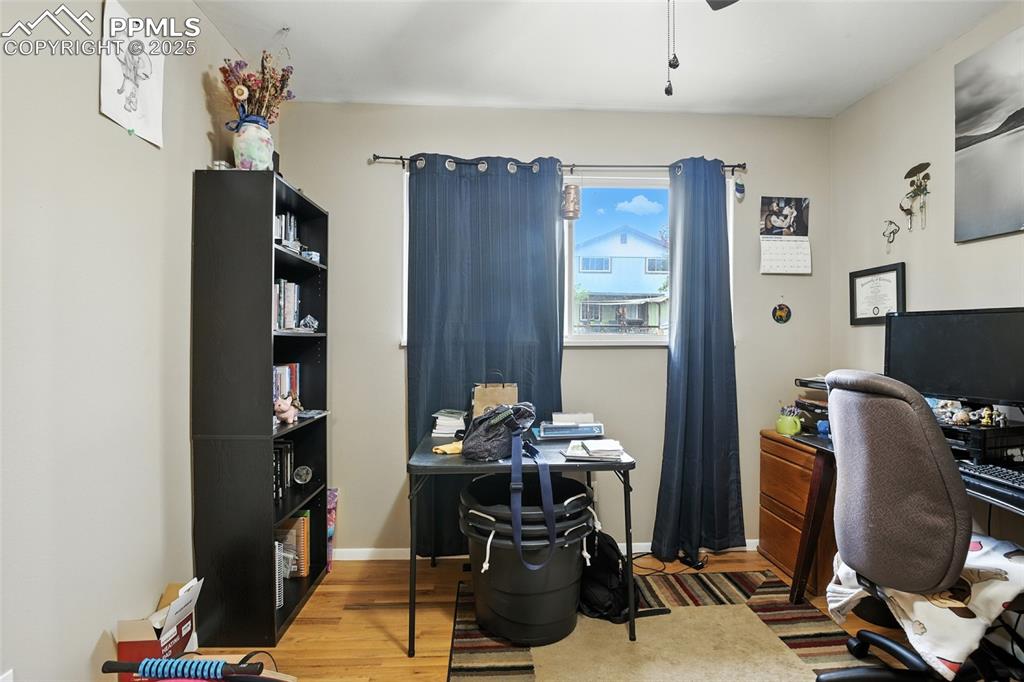 Office space with light wood-type flooring and a ceiling fan