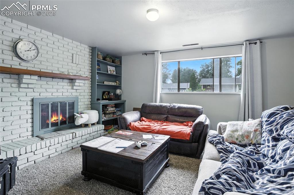 Living room with carpet floors and a brick fireplace