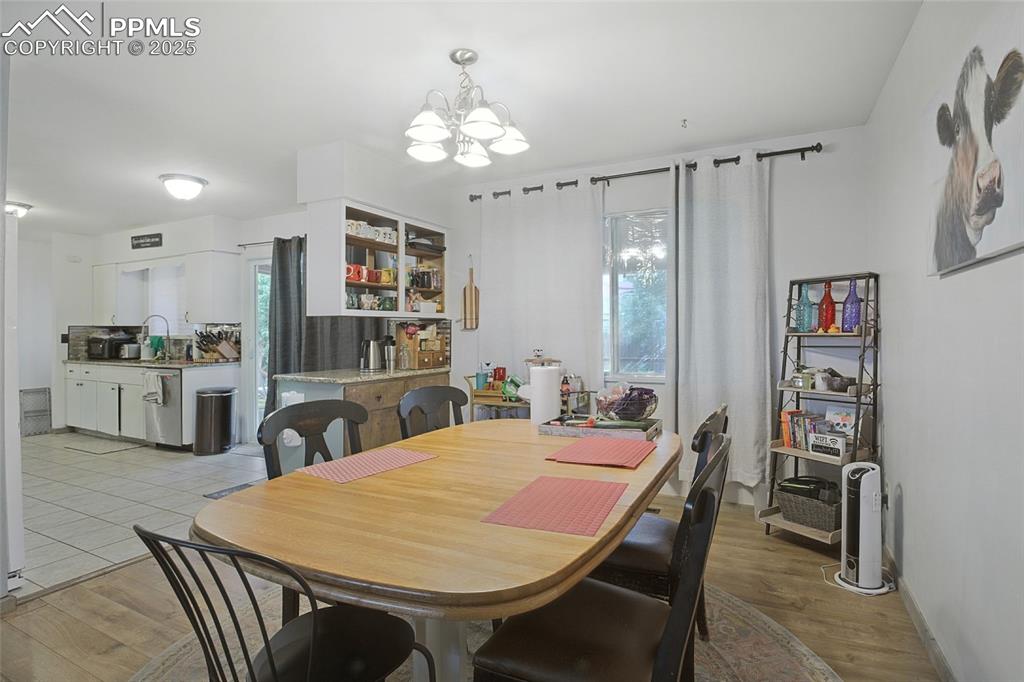 Dining area with healthy amount of natural light, a chandelier, and light wood-style floors