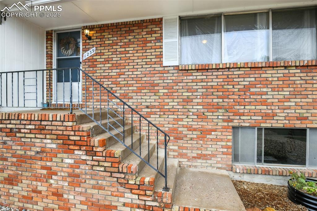 View of exterior entry with brick siding