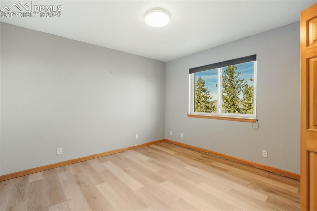 Spare room with baseboards and light wood-type flooring