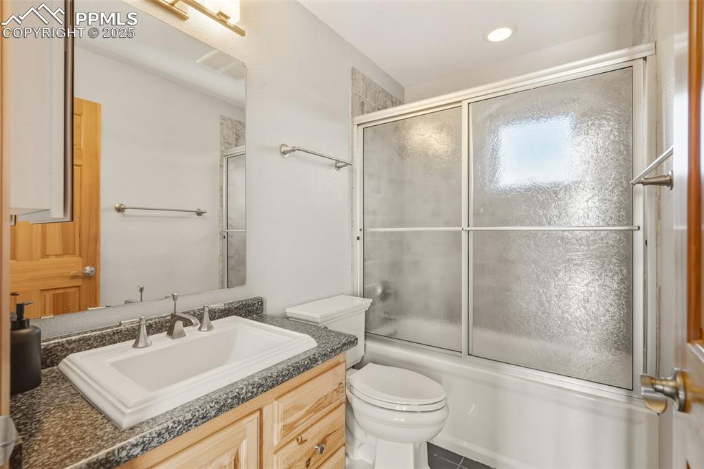 Full bath with vanity and shower / bath combination with glass door