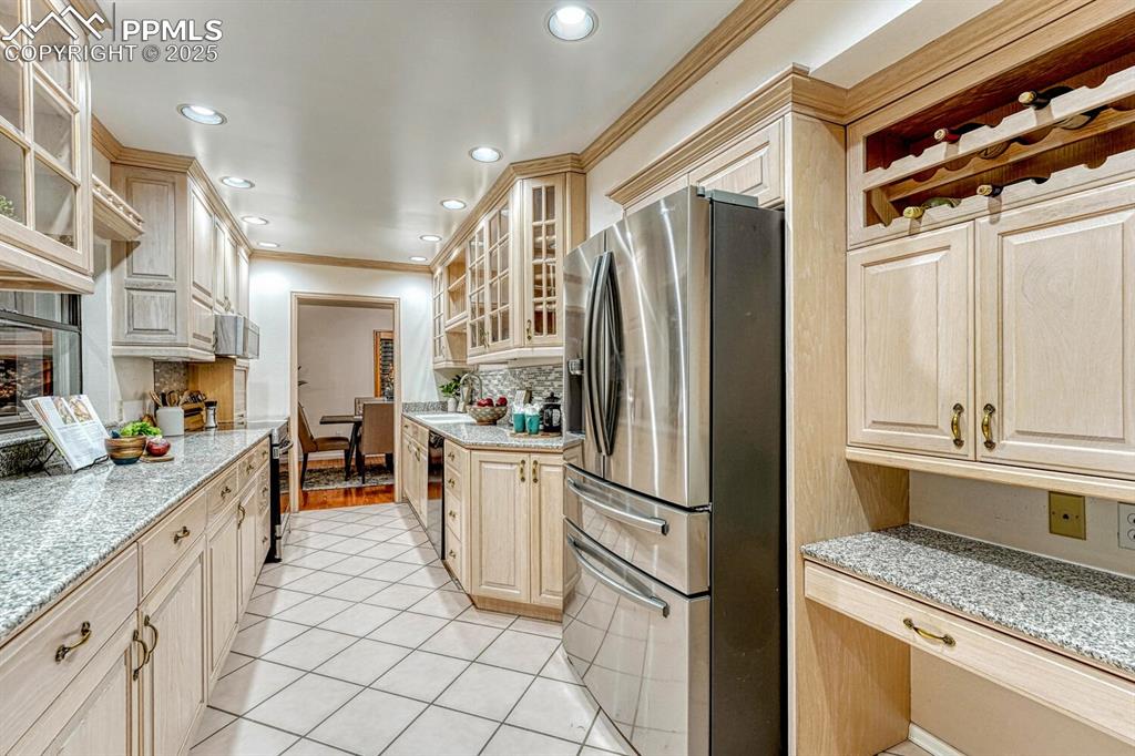 The beautifully updated Kitchen offers a tile floor, planning desk, abundant cabinets w/ granite countertops, & quality  stainless steel appliances.